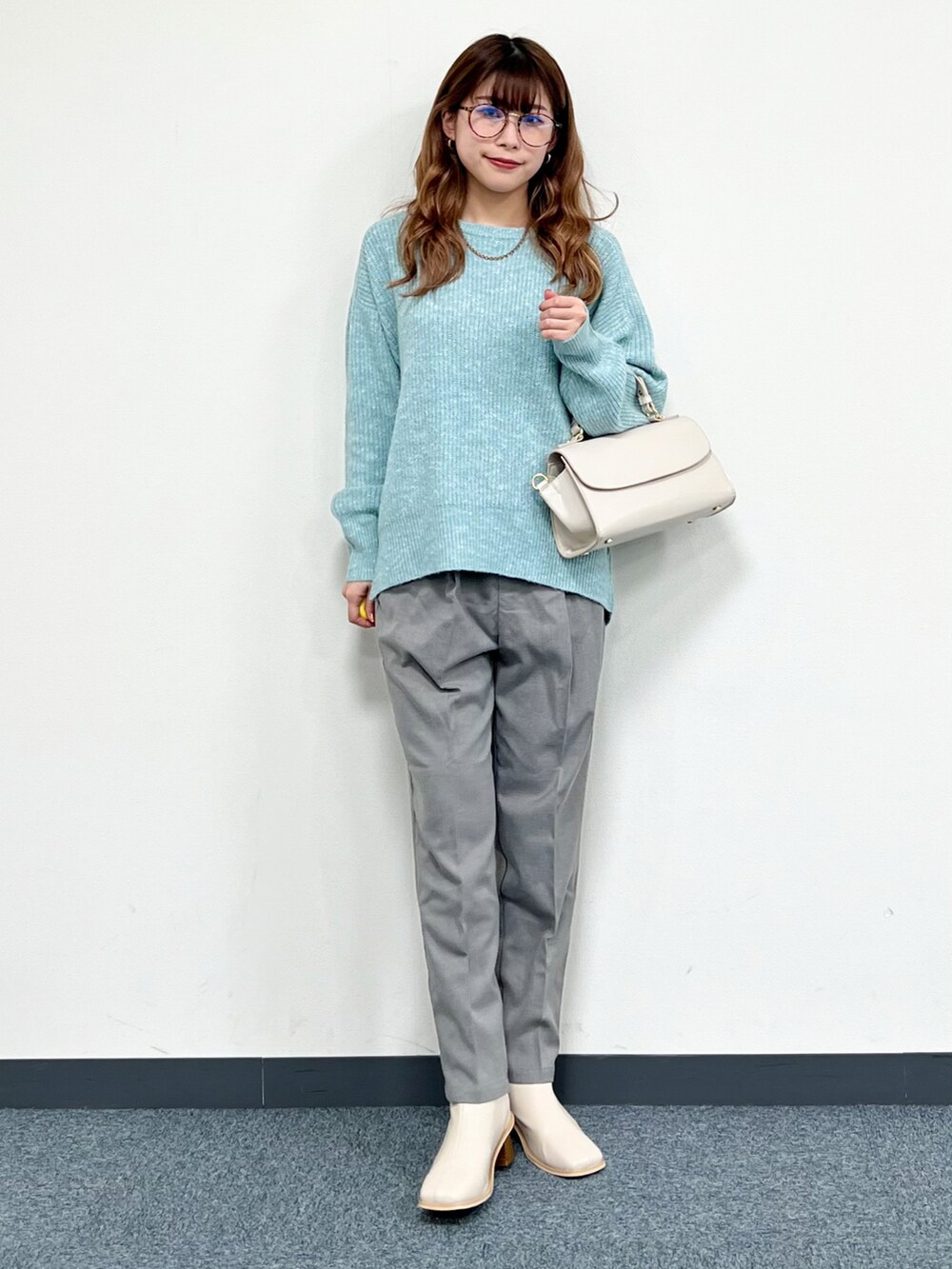 ホワイト系のブルゾン、ブルー系のニット/セーター、グレー系のその他パンツを着用したレディースの冬コーディネートの5枚目の写真