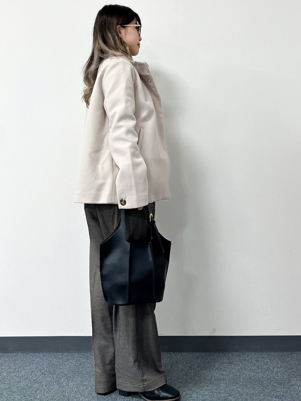 ベージュ系のその他アウター、ホワイト系のニット/セーター、ブラック系のトートバッグを着用したレディースの冬コーディネートの3枚目の写真