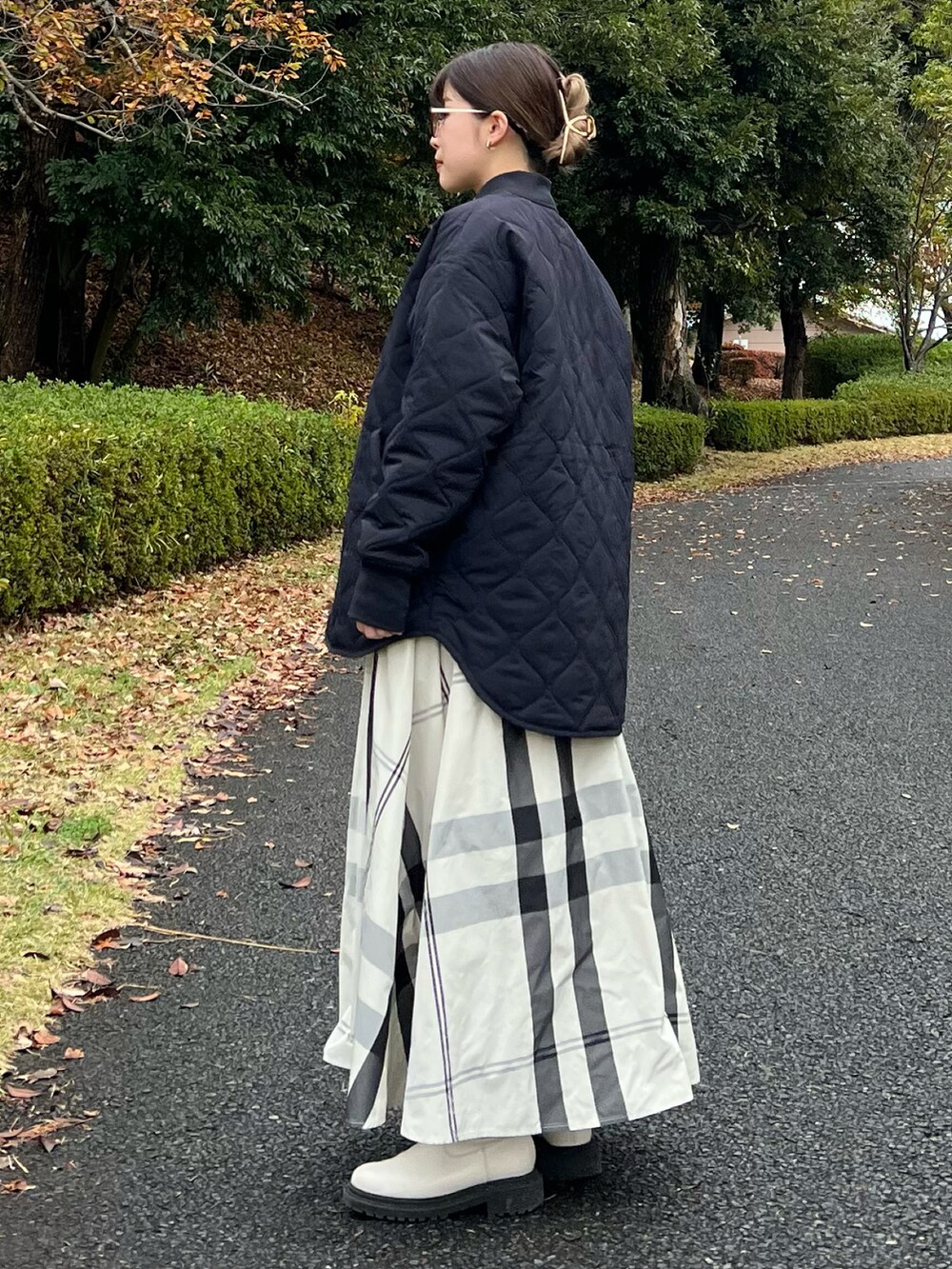 ブラック系のブルゾン、グリーン系のニット/セーター、ホワイト系のスカートを着用したレディースの冬コーディネートの4枚目の写真