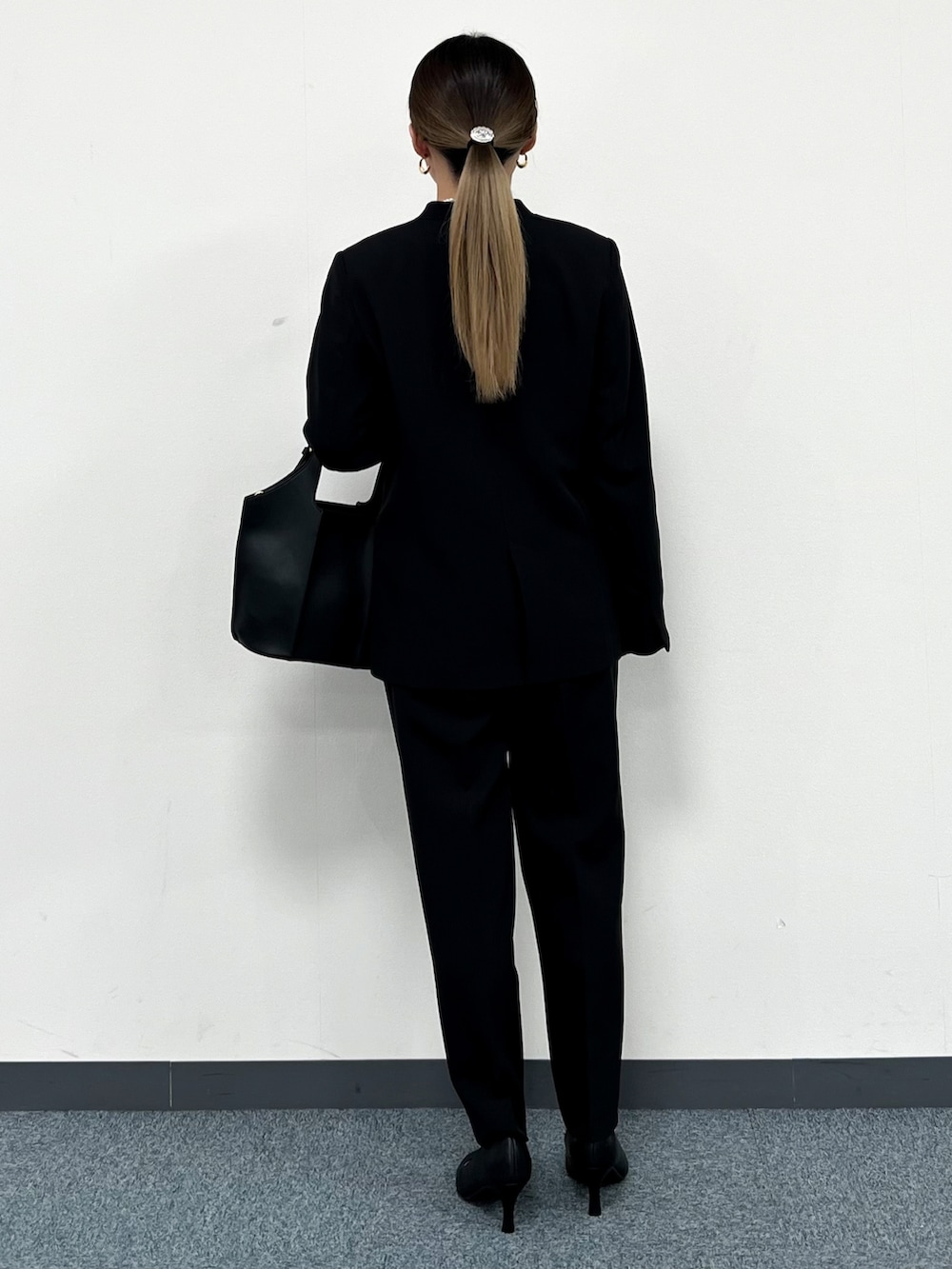 ホワイト系のシャツ/ブラウス、ブラック系のノーカラージャケット、ブラック系のトートバッグを着用したレディースの冬コーディネートの3枚目の写真