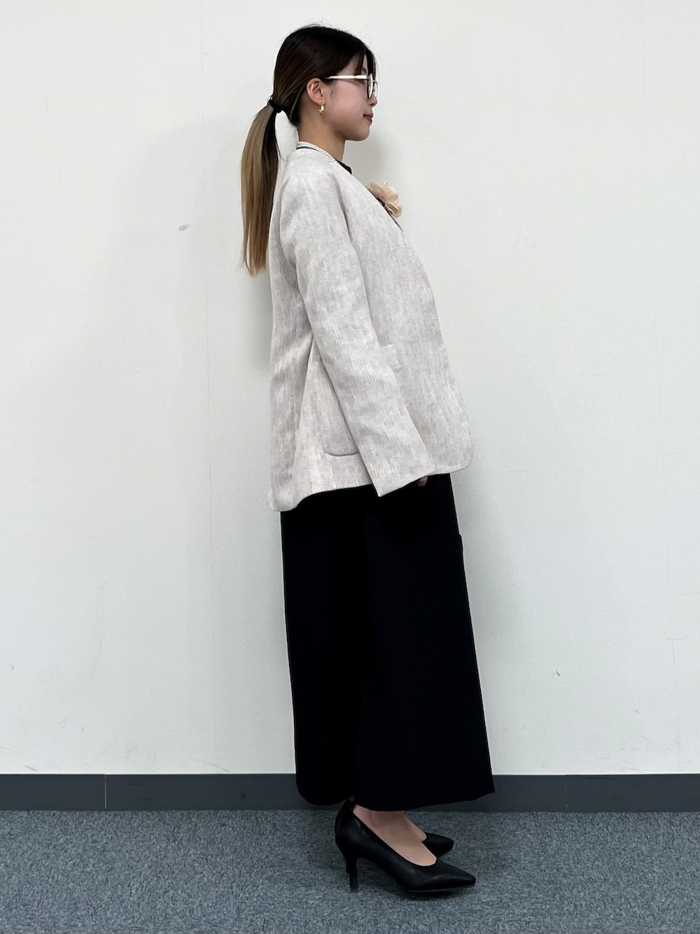 ベージュ系のノーカラージャケット、ブラック系のワンピース、ブラック系のトートバッグを着用したレディースの冬コーディネートの2枚目の写真