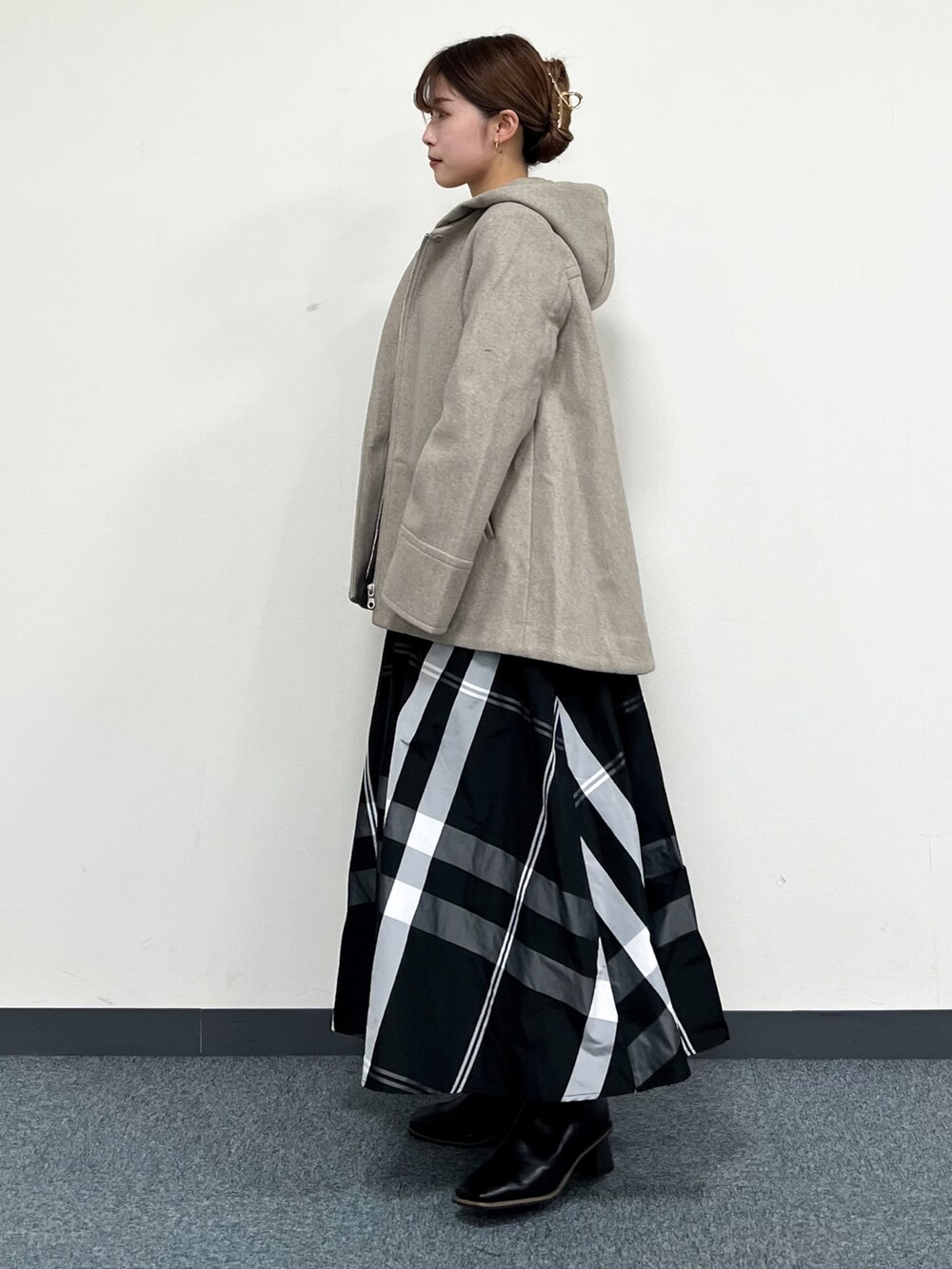 ブラウン系のその他アウター、イエロー系のニット/セーター、ブラック系のスカートを着用したレディースの冬コーディネートの4枚目の写真