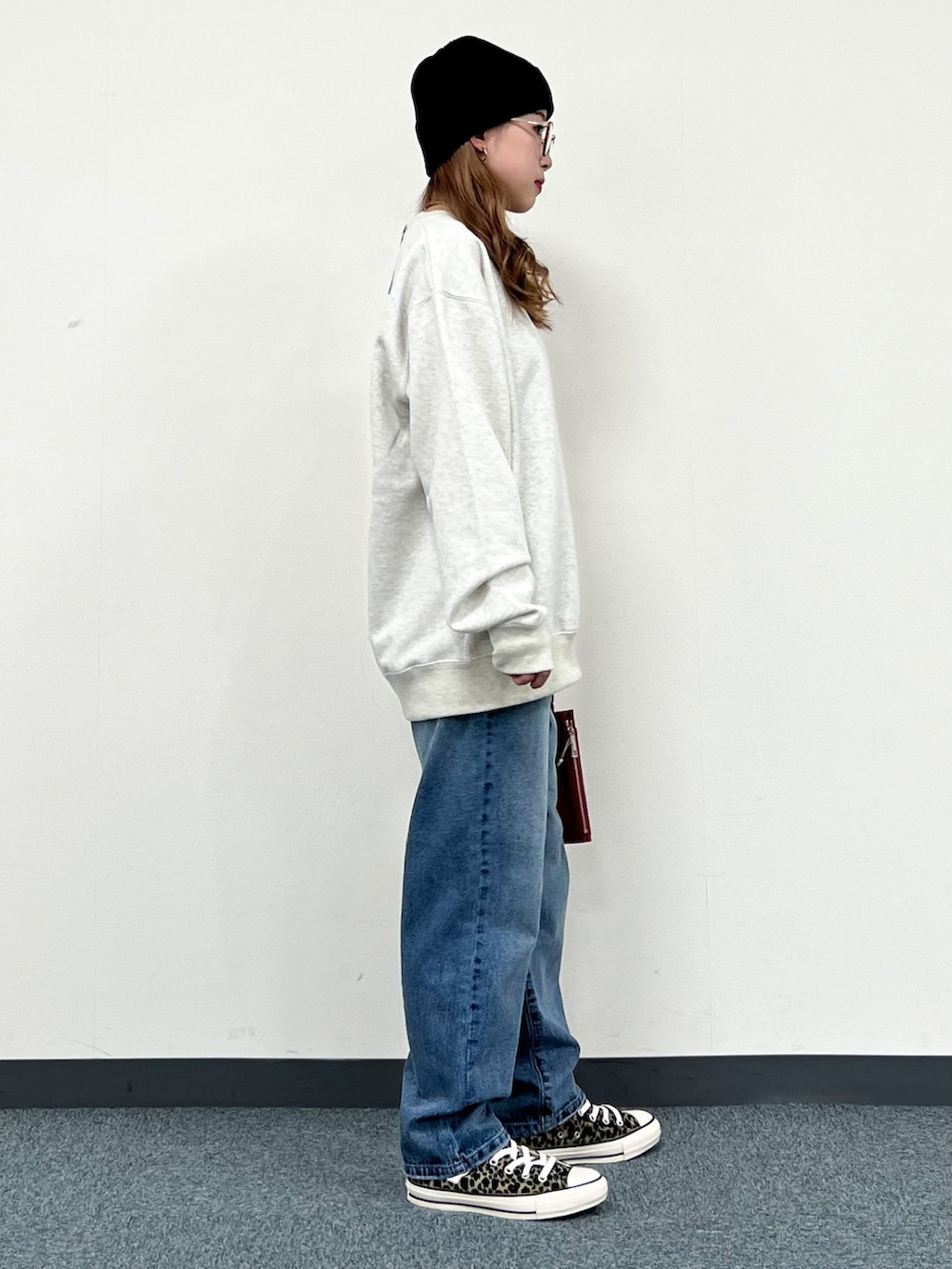 ホワイト系のスウェット、ピンク系のショルダーバッグ、ブルー系のその他パンツを着用したレディースの冬コーディネートの3枚目の写真