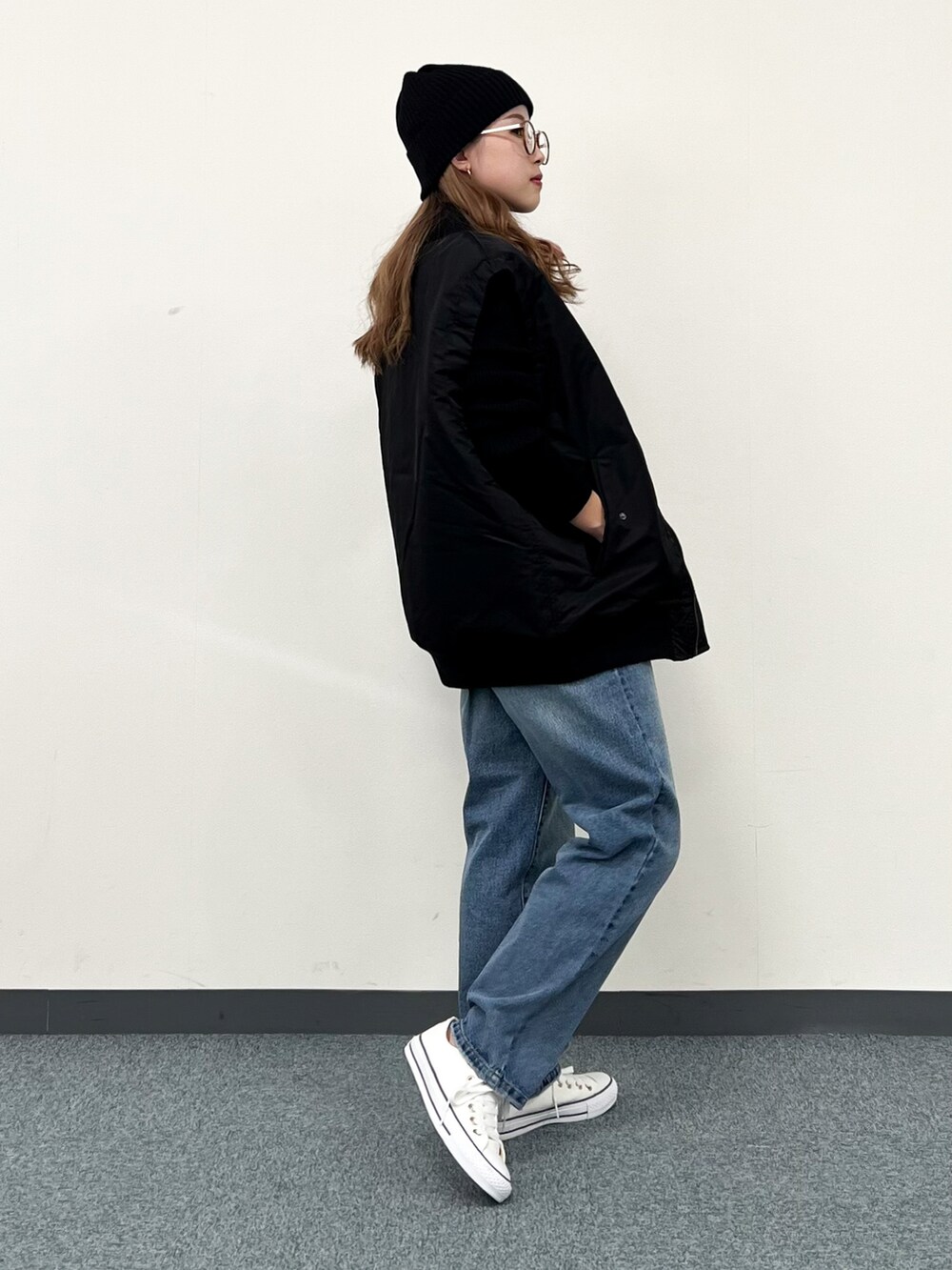 ブラック系のブルゾン、ブラック系のニット/セーター、ブルー系のその他パンツを着用したレディースの冬コーディネートの4枚目の写真