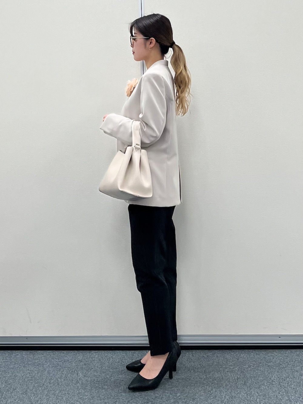 グレー系のノーカラージャケット、ベージュ系のトートバッグ、ブラック系のその他パンツを着用したレディースの冬コーディネートの2枚目の写真