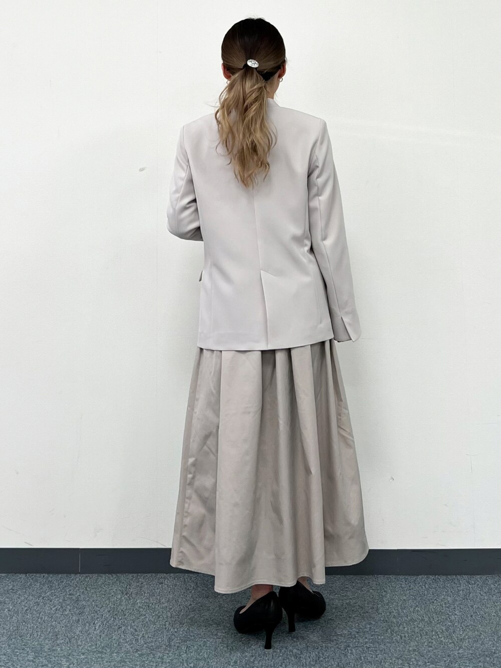 ホワイト系のシャツ/ブラウス、グレー系のノーカラージャケット、ベージュ系のスカートを着用したレディースの冬コーディネートの3枚目の写真