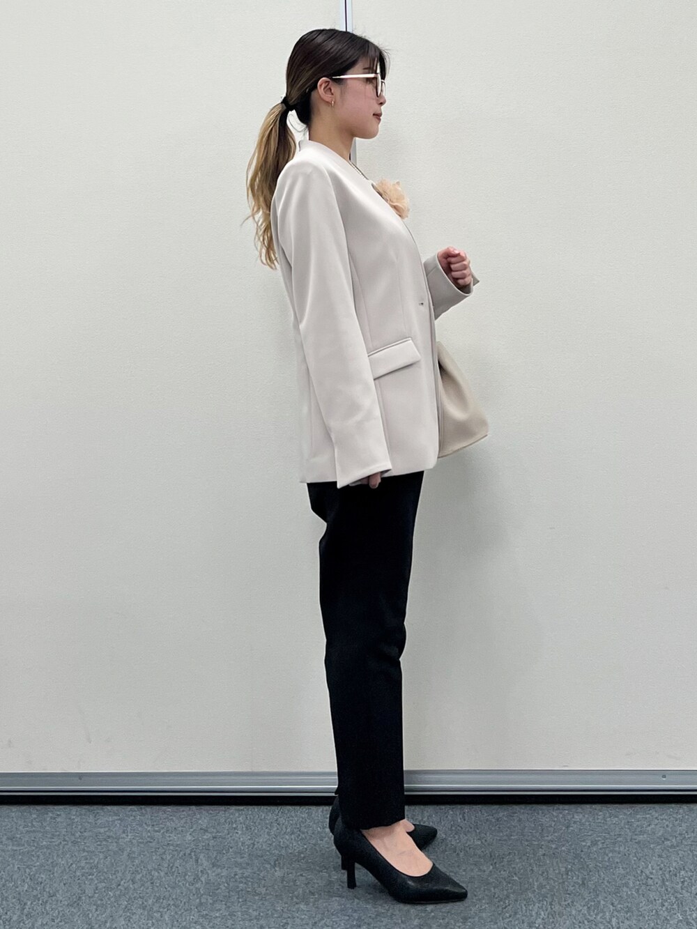 グレー系のノーカラージャケット、ベージュ系のトートバッグ、ブラック系のその他パンツを着用したレディースの冬コーディネートの4枚目の写真