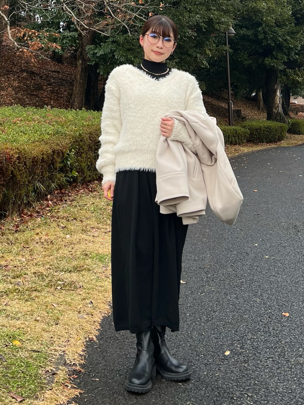 ベージュ系のその他アウター、ホワイト系のニット/セーター、ベージュ系のハンドバッグを着用したレディースの冬コーディネートの5枚目の写真