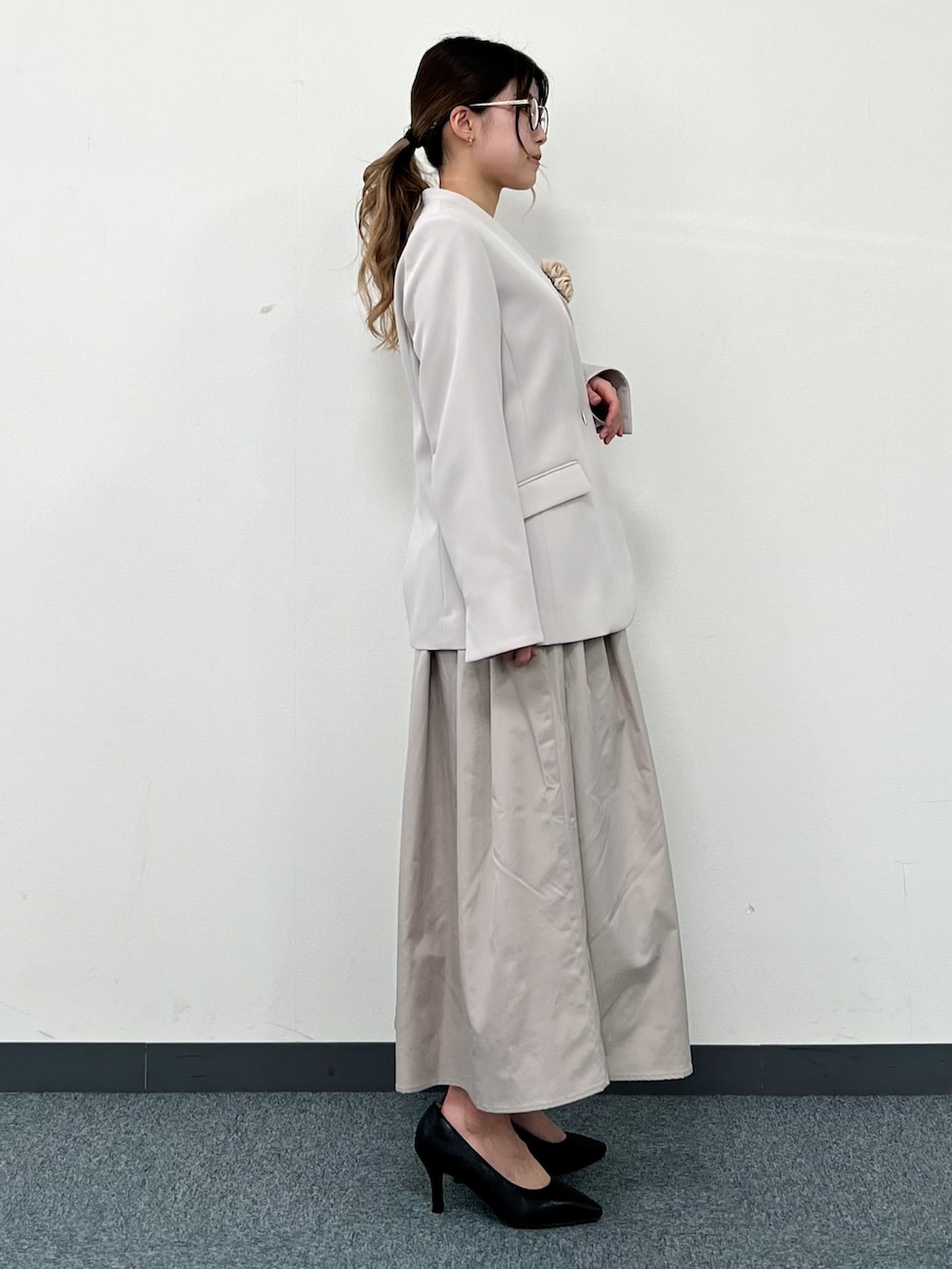 ホワイト系のシャツ/ブラウス、グレー系のノーカラージャケット、ベージュ系のスカートを着用したレディースの冬コーディネートの2枚目の写真