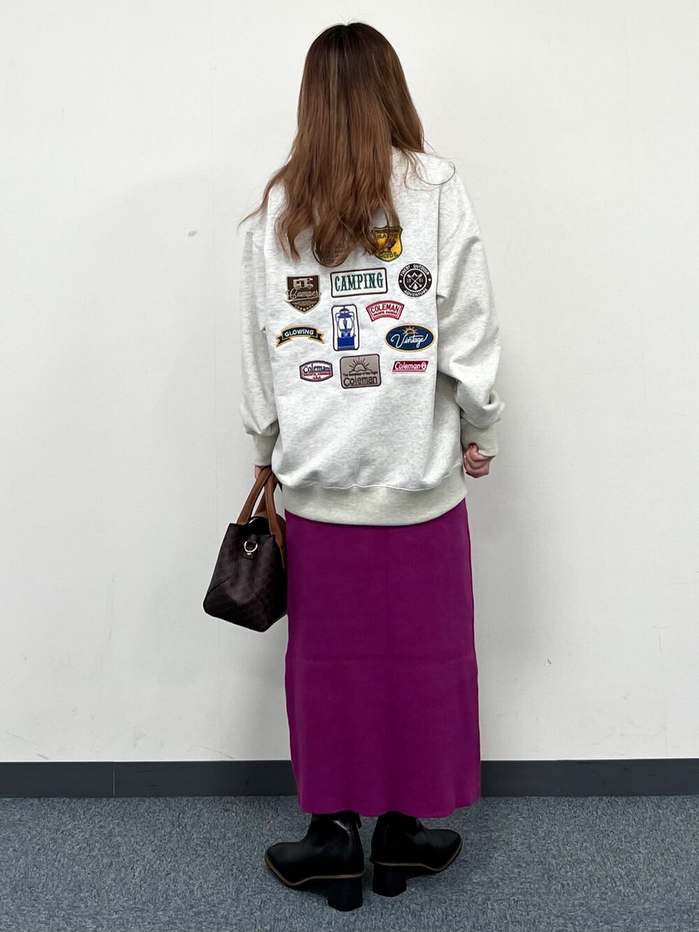 ベージュ系のダウンベスト、ホワイト系のスウェット、ブラウン系のショルダーバッグを着用したレディースの冬コーディネートの5枚目の写真