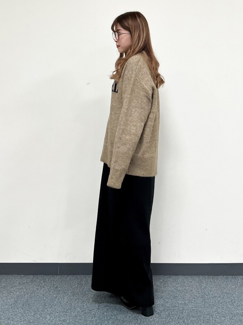 ブラウン系のショルダーバッグ、ベージュ系のニット/セーター、ブラック系のワンピースを着用したレディースの冬コーディネートの5枚目の写真