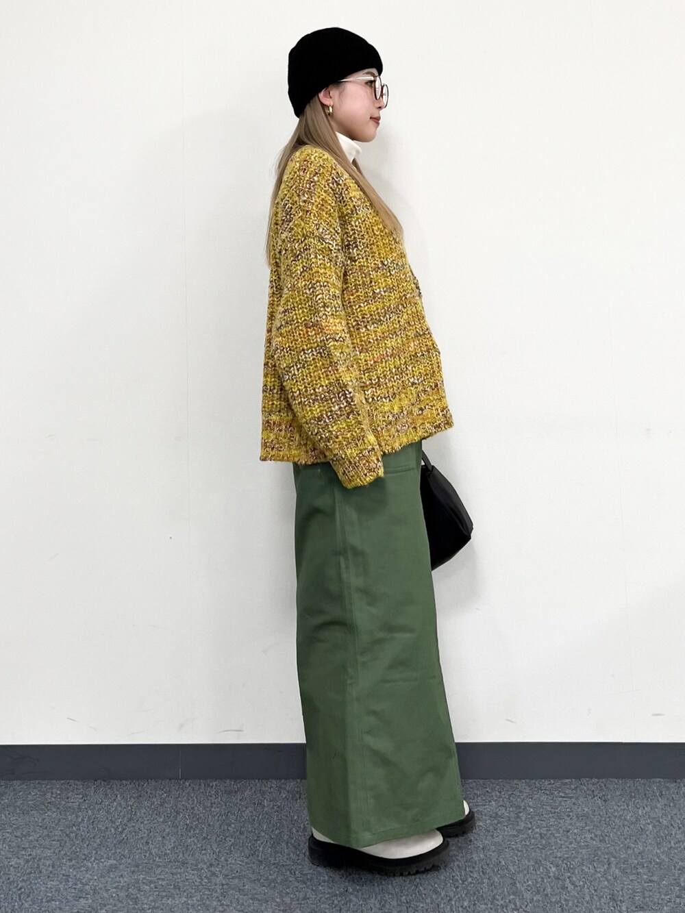 ホワイト系のTシャツ/カットソー、イエロー系のカーディガン/ボレロ、ブラック系のトートバッグを着用したレディースの冬コーディネートの2枚目の写真