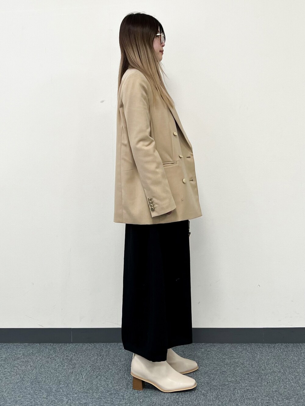 ブラック系のワンピース、ベージュ系のテーラードジャケット、ブラック系のショルダーバッグを着用したレディースの冬コーディネートの2枚目の写真