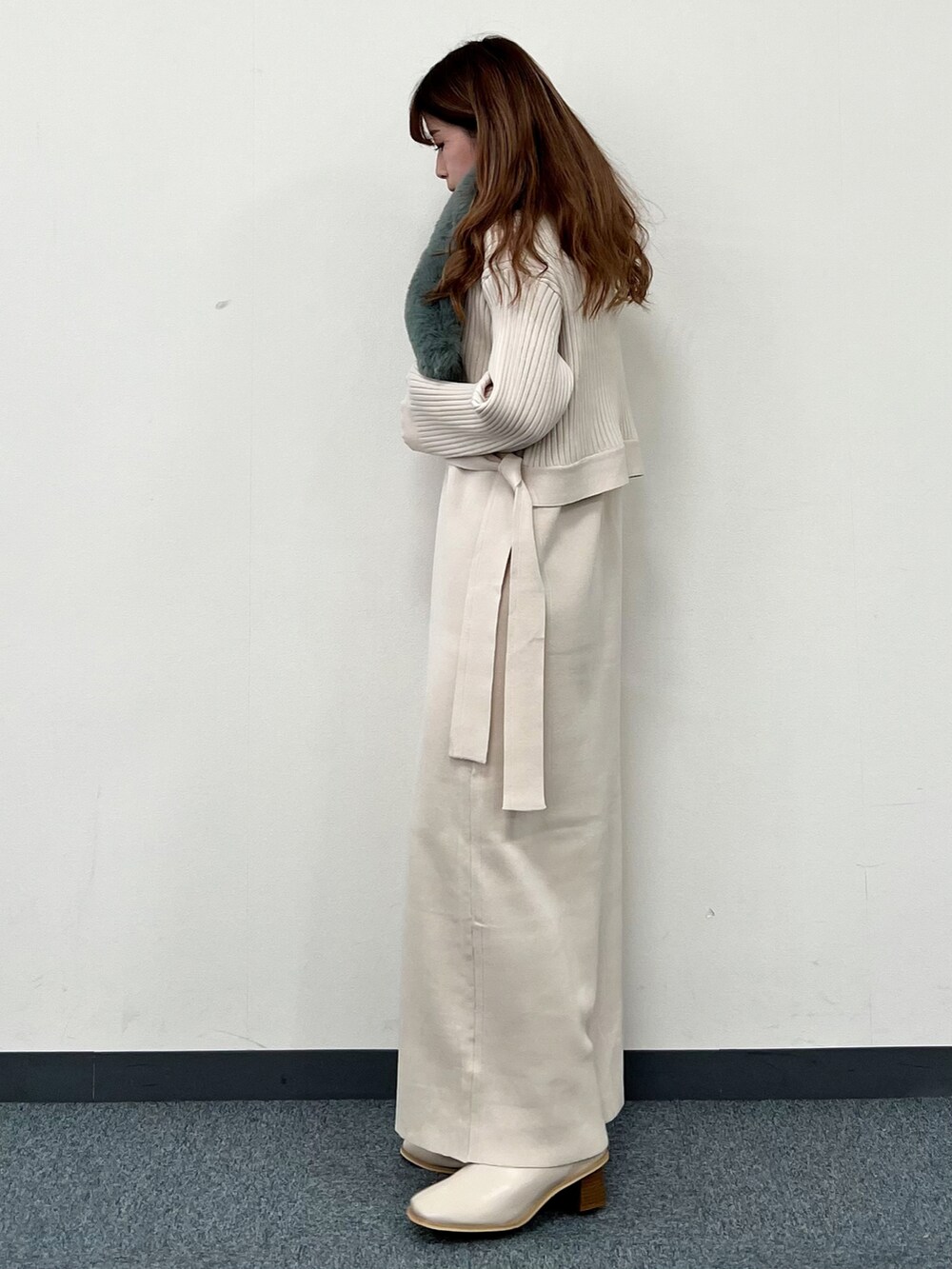 ベージュ系のワンピース、ベージュ系のブーツ、グリーン系のストール/ショールを着用したレディースの冬コーディネートの4枚目の写真