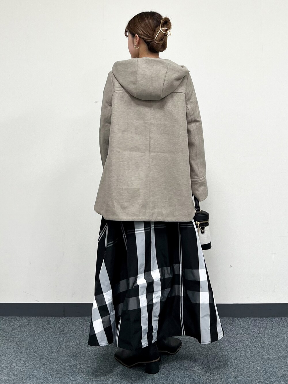 ブラウン系のその他アウター、イエロー系のニット/セーター、ブラック系のスカートを着用したレディースの冬コーディネートの3枚目の写真