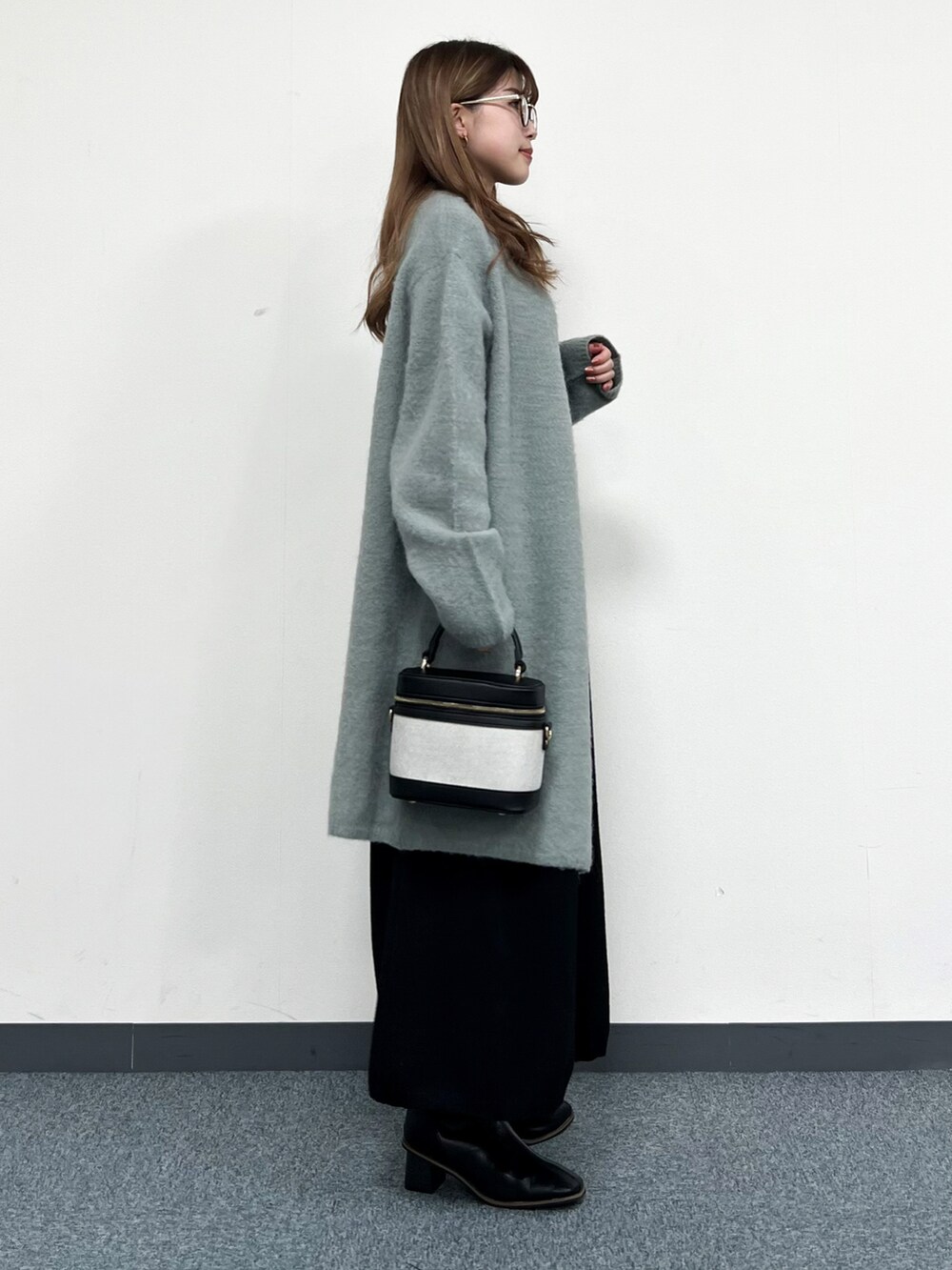 グリーン系のカーディガン/ボレロ、ブラック系のショルダーバッグ、ブラック系のワンピースを着用したレディースの冬コーディネートの2枚目の写真