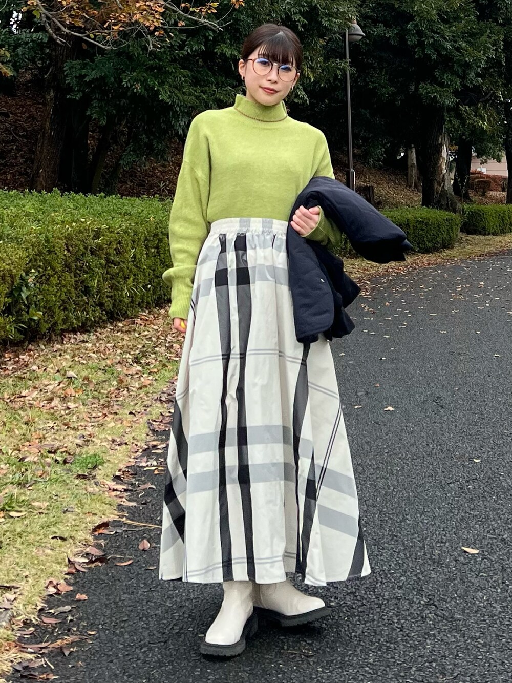 ブラック系のブルゾン、グリーン系のニット/セーター、ホワイト系のスカートを着用したレディースの冬コーディネートの5枚目の写真