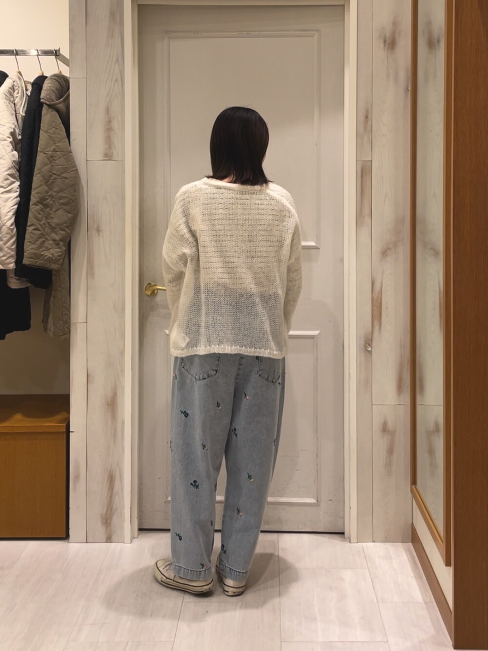 ブルー系のデニムパンツ、ホワイト系のカーディガン/ボレロを着用したレディースの冬コーディネートの3枚目の写真