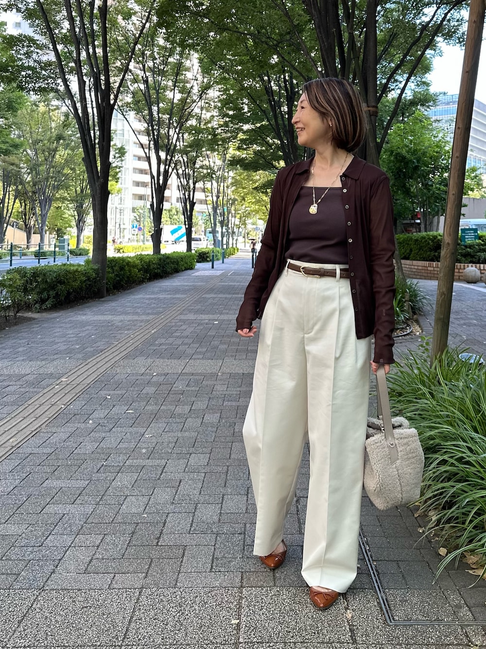 ブラウン系のカーディガン/ボレロ、ブラウン系のタンクトップ、ホワイト系のその他パンツを着用したレディースの秋コーディネートの2枚目の写真