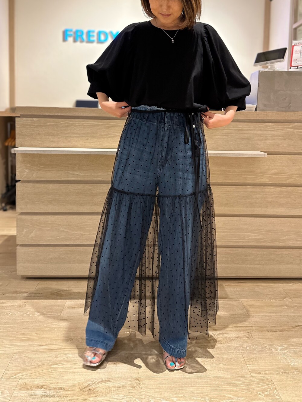 ブラック系のTシャツ/カットソー、ブラック系のスカート、ブルー系のデニムパンツを着用したレディースの夏コーディネートの2枚目の写真