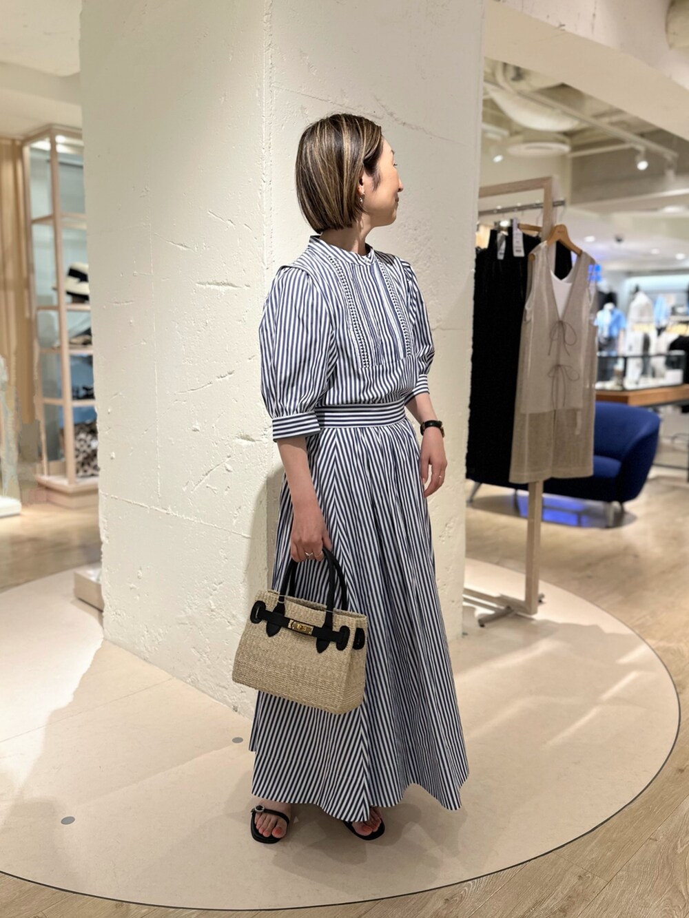 ホワイト系のシャツ/ブラウス、ホワイト系のスカート、ブラック系のかごバッグを着用したレディースの夏コーディネートの4枚目の写真