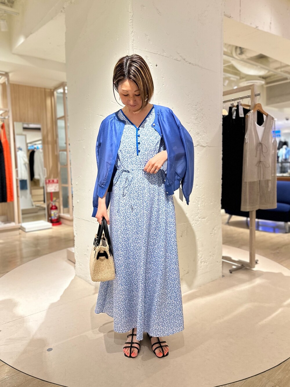 ブラック系のかごバッグ、ブルー系のカーディガン/ボレロ、ブルー系のワンピースを着用したレディースの夏コーディネートの4枚目の写真