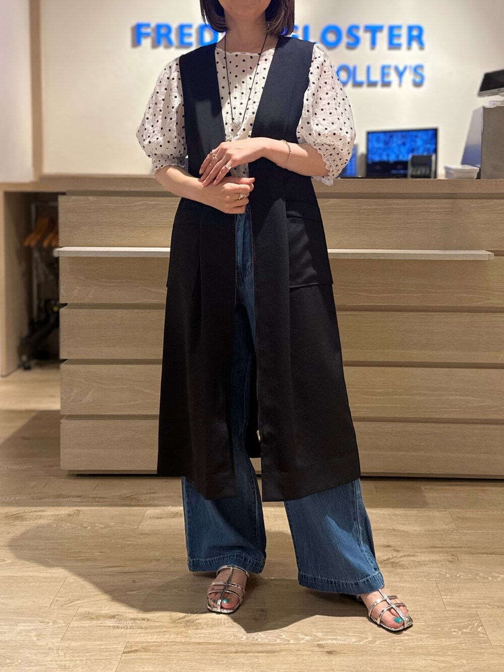 ホワイト系のシャツ/ブラウス、シルバー系のサンダル、ブルー系のデニムパンツを着用したレディースの夏コーディネートの2枚目の写真