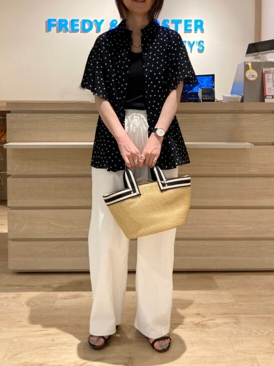 ブラック系のシャツ/ブラウス、ホワイト系のスラックス、ベージュ系のトートバッグを着用したレディースの春コーディネートの3枚目の写真