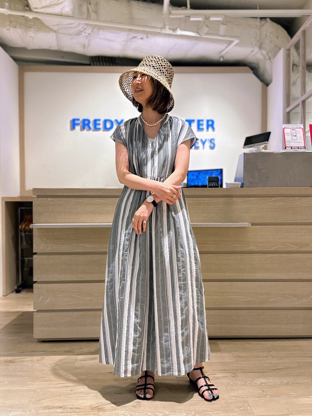 ブラック系のワンピース、ベージュ系のハットを着用したレディースの夏コーディネートの2枚目の写真