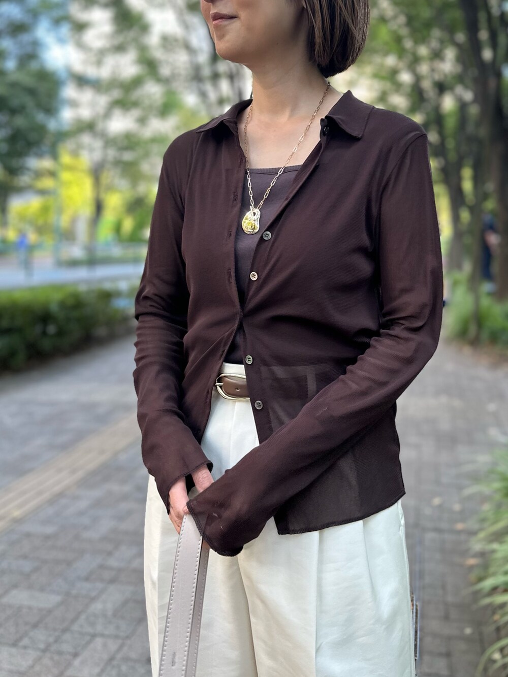 ブラウン系のカーディガン/ボレロ、ブラウン系のタンクトップ、ホワイト系のその他パンツを着用したレディースの秋コーディネートの7枚目の写真