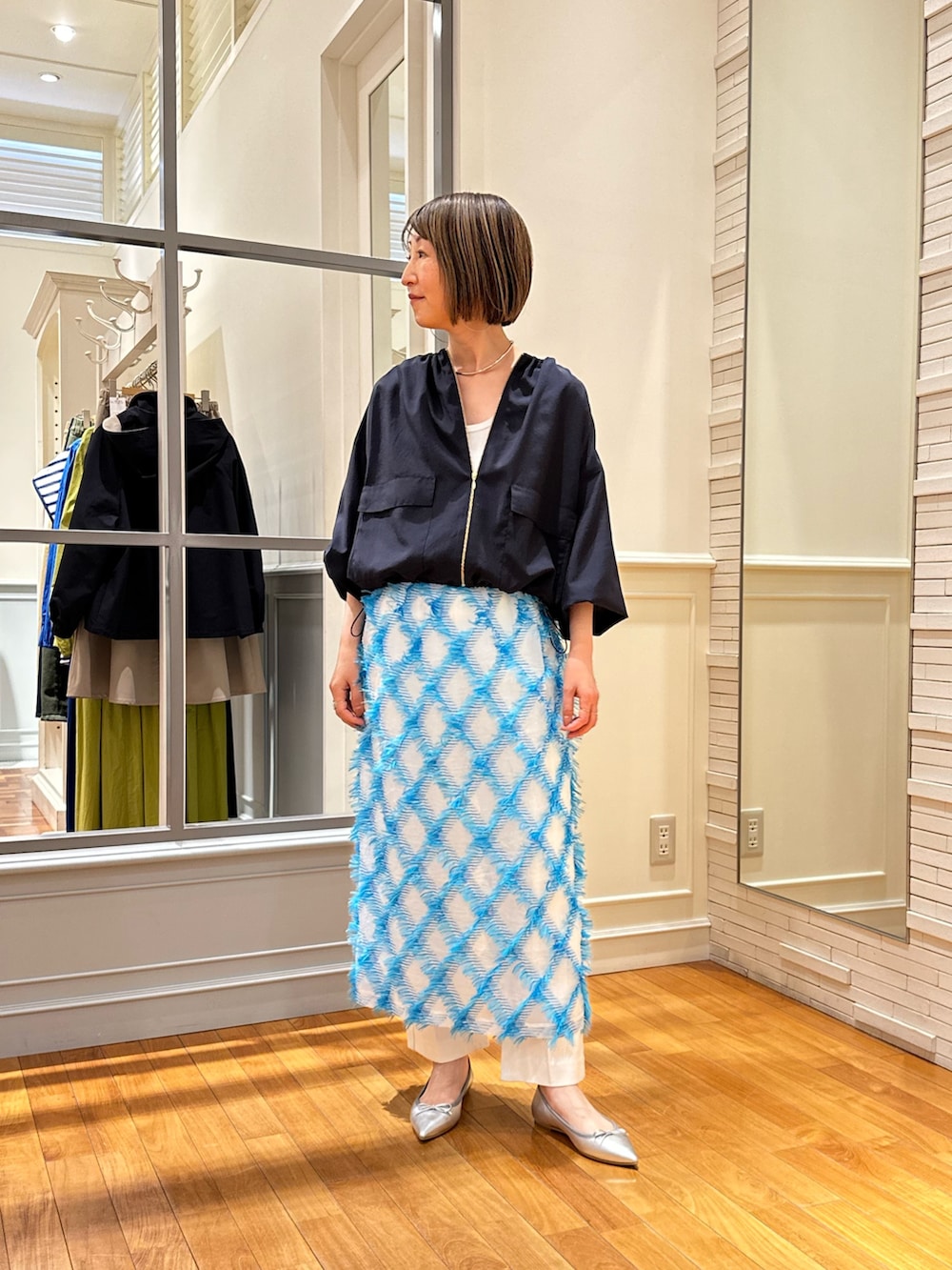 ホワイト系のデニムパンツ、ブルー系のスカート、ホワイト系のタンクトップを着用したレディースの春コーディネートの2枚目の写真