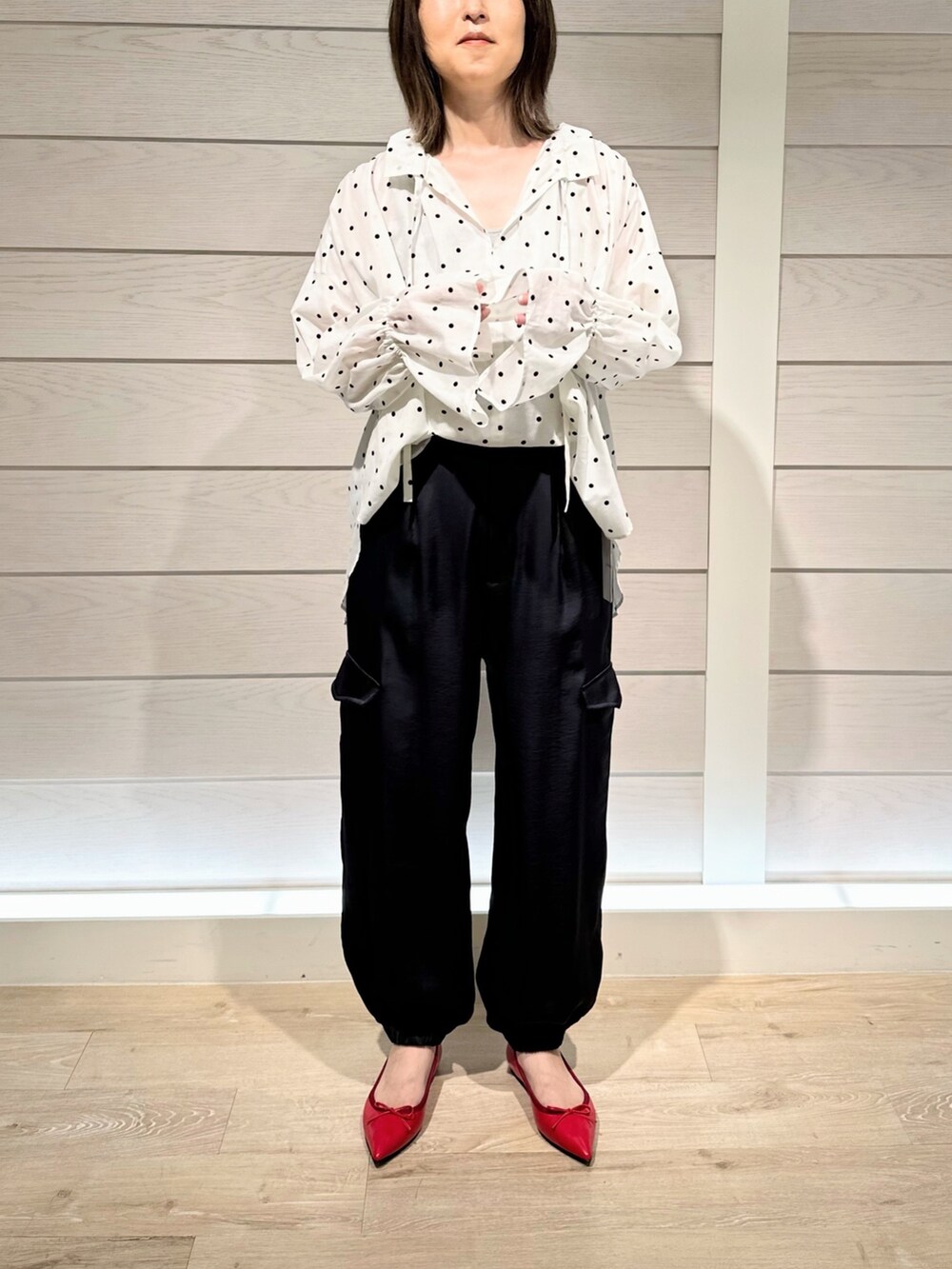 レッド系のパンプス、ホワイト系のシャツ/ブラウス、ブルー系のカーゴパンツを着用したレディースの秋コーディネートの2枚目の写真