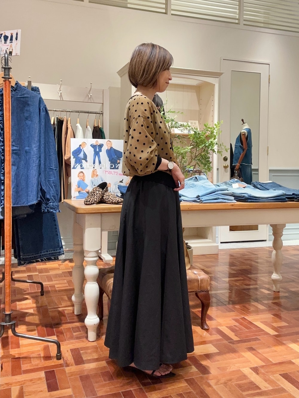 ブラック系のタンクトップ、イエロー系のカーディガン/ボレロ、ブラック系のスカートを着用したレディースの夏コーディネートの3枚目の写真