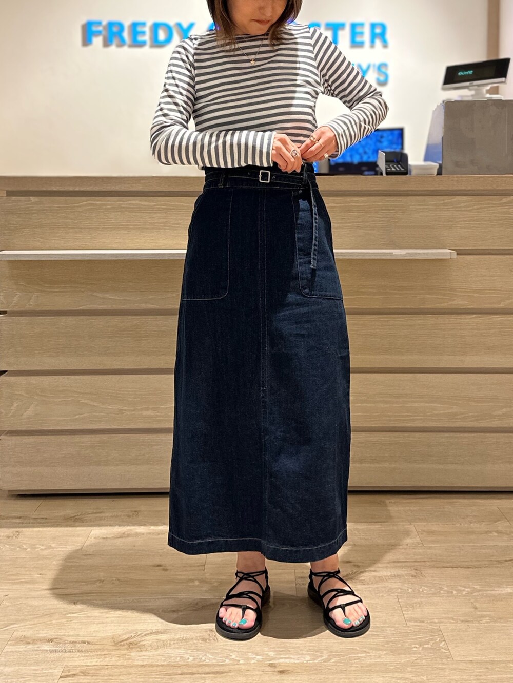 グレー系のTシャツ/カットソー、ブルー系のデニムスカートを着用したレディースの夏コーディネートの2枚目の写真