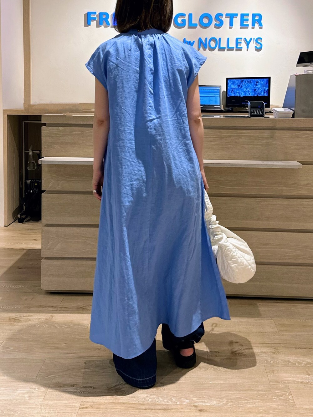 ホワイト系のショルダーバッグ、ブルー系のワンピース、ブルー系のデニムパンツを着用したレディースの夏コーディネートの3枚目の写真