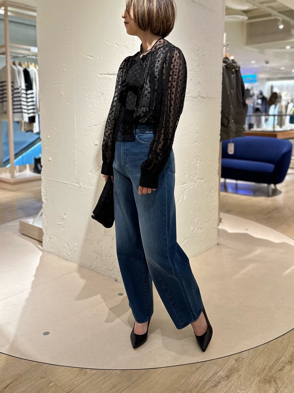 ブラック系のシャツ/ブラウス、ブラック系のパンプス、ブルー系のデニムパンツを着用したレディースの冬コーディネートの2枚目の写真