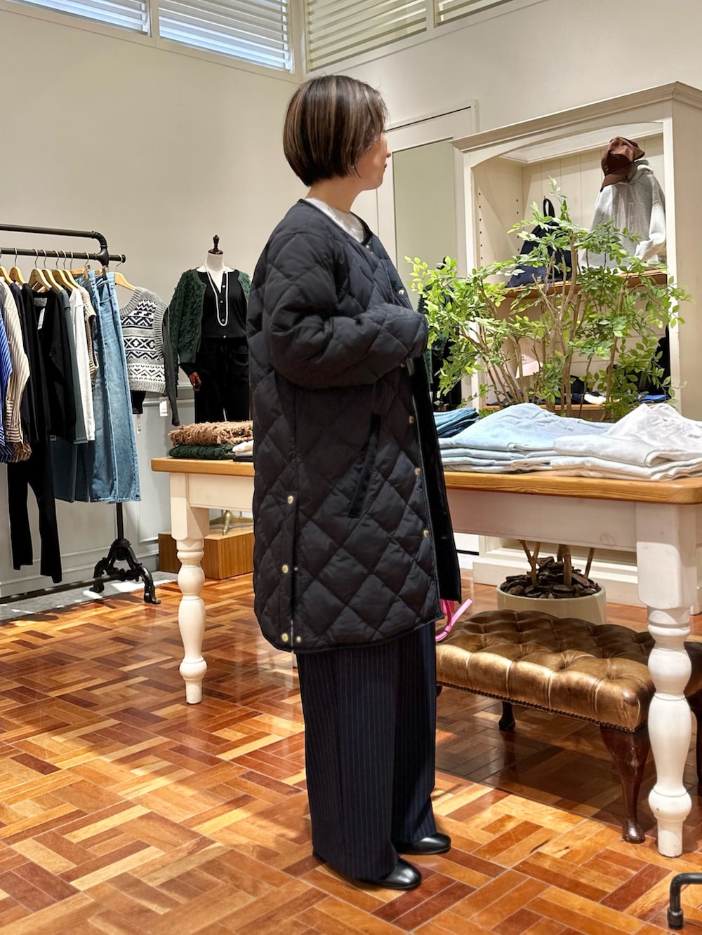 ブラック系のダウンジャケット/コート、グレー系のニット/セーター、ブルー系のその他パンツを着用したレディースの秋コーディネートの4枚目の写真