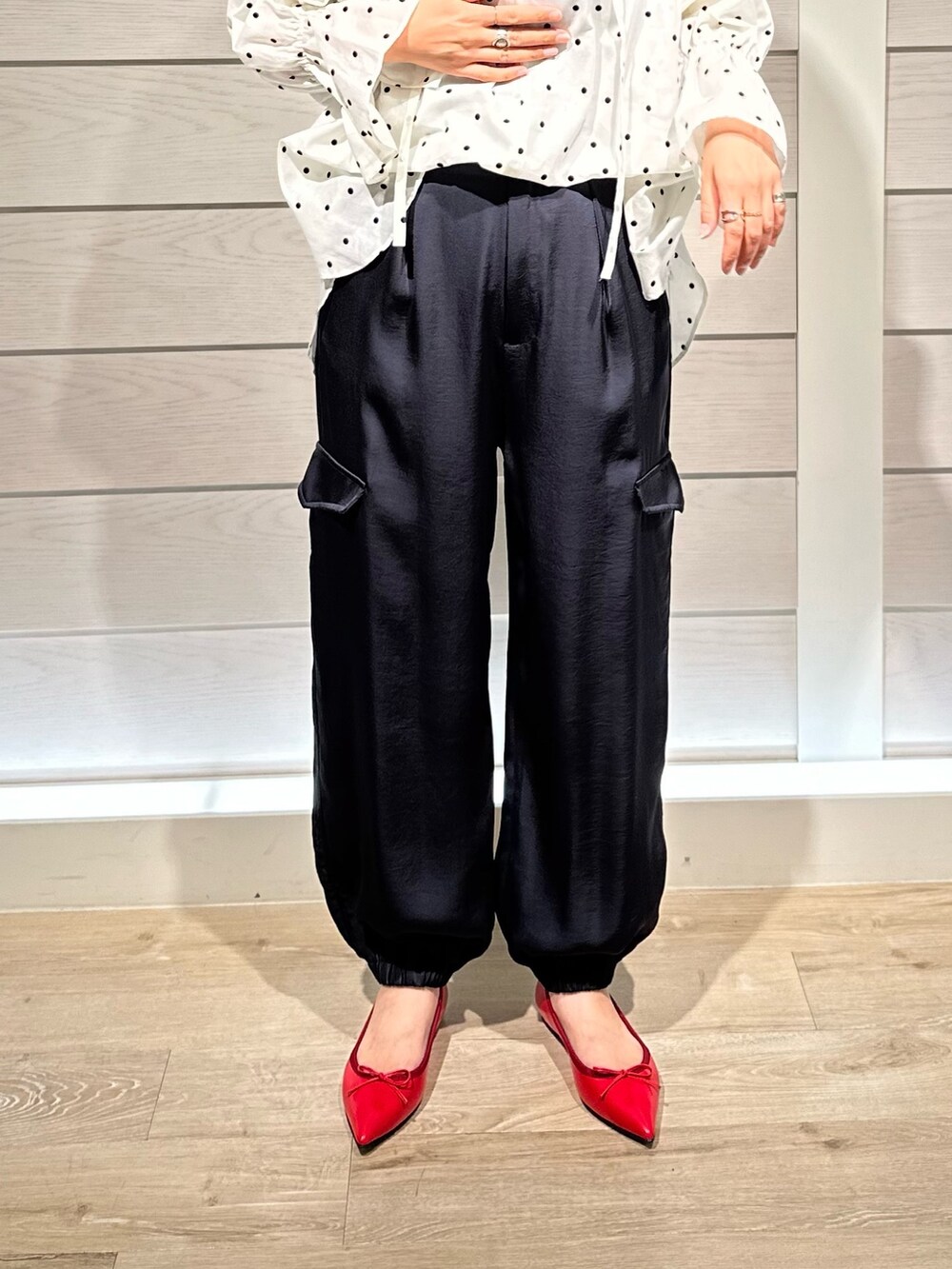 レッド系のパンプス、ホワイト系のシャツ/ブラウス、ブルー系のカーゴパンツを着用したレディースの秋コーディネートの3枚目の写真