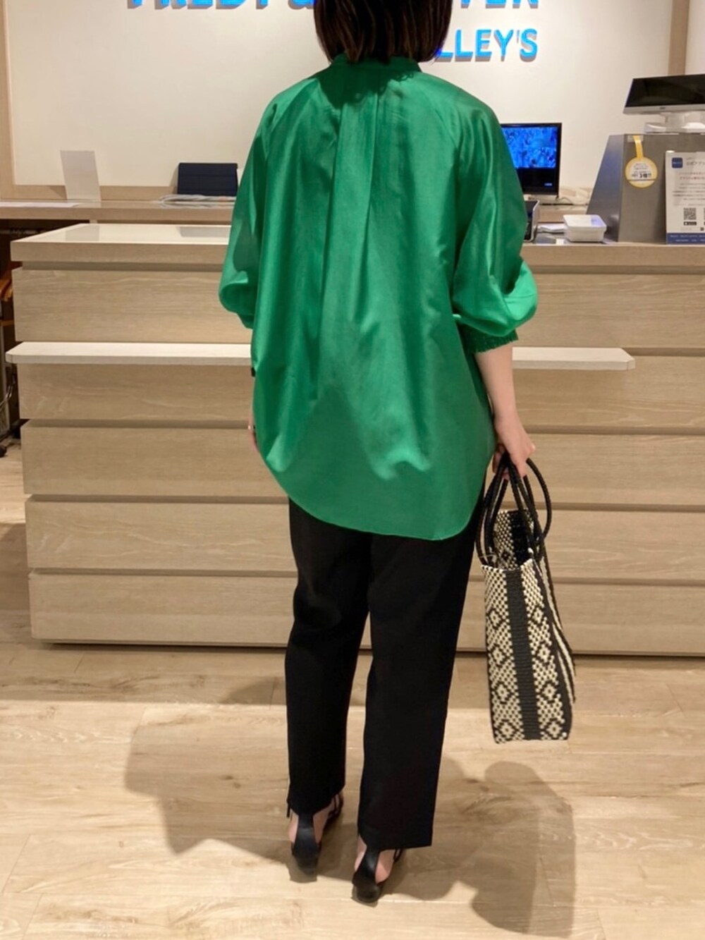 ブラック系のスラックス、グリーン系のシャツ/ブラウス、ブラック系のサンダルを着用したレディースの夏コーディネートの3枚目の写真