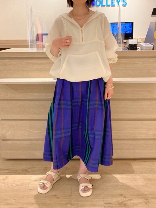 ホワイト系のブルゾン、ホワイト系のタンクトップ、ブルー系のスカートを着用したレディースの春コーディネートの2枚目の写真