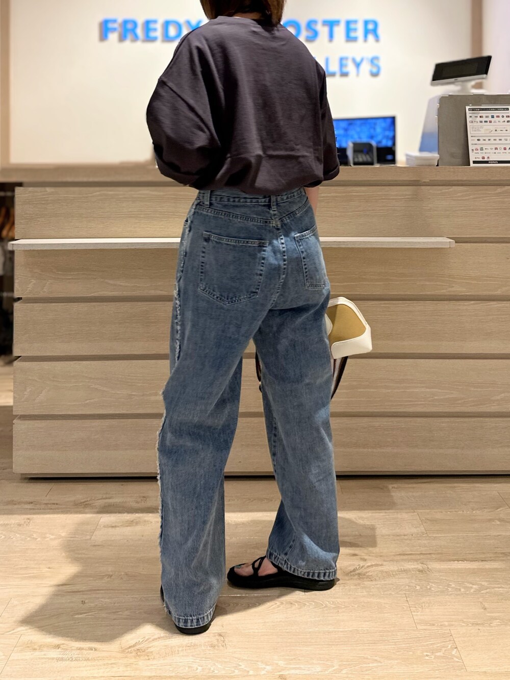 ホワイト系のショルダーバッグ、グレー系のTシャツ/カットソー、ブルー系のデニムパンツを着用したレディースの夏コーディネートの3枚目の写真