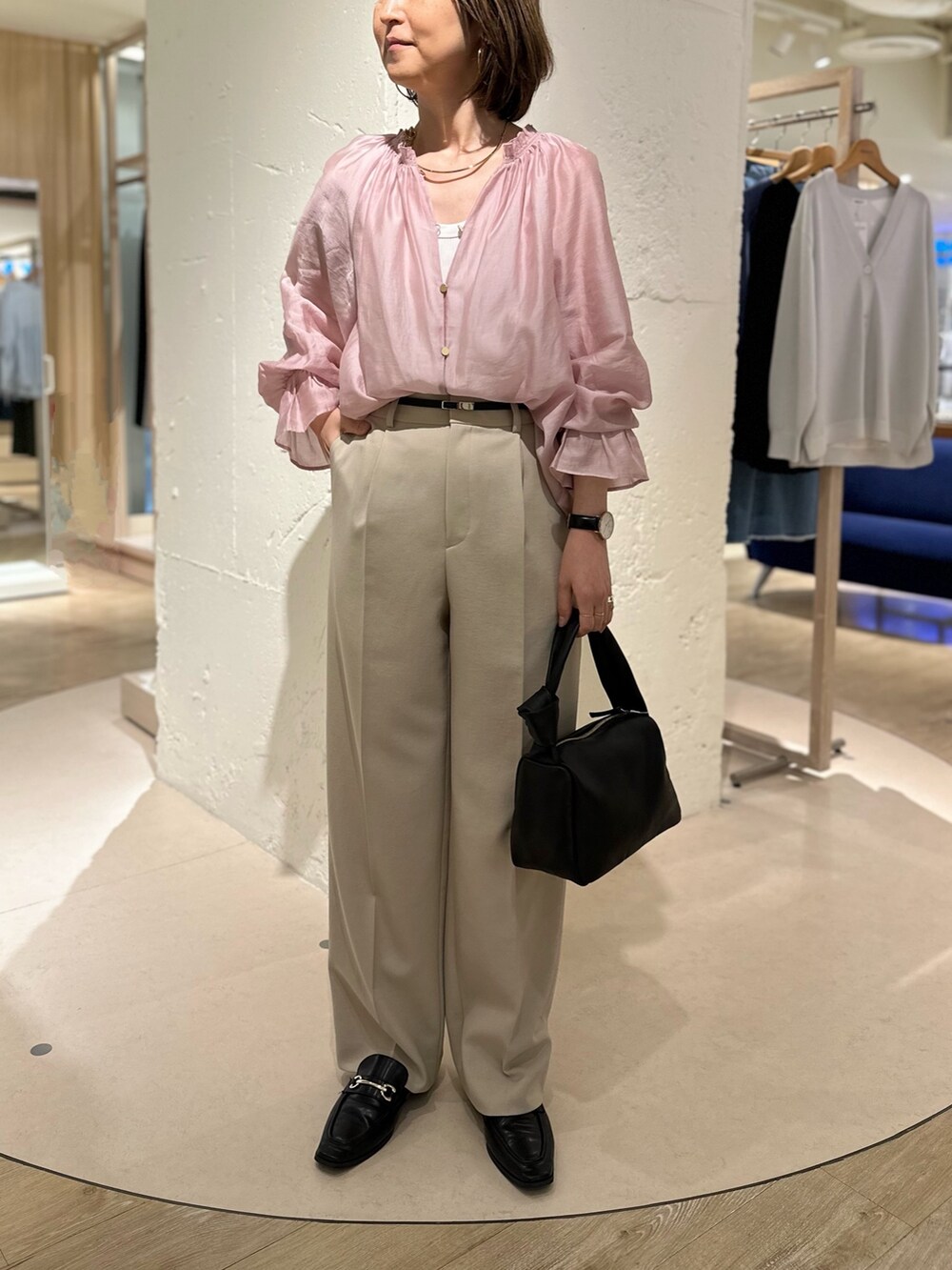 ピンク系のシャツ/ブラウス、ベージュ系のその他パンツ、ブラック系のショルダーバッグを着用したレディースの春コーディネートの2枚目の写真