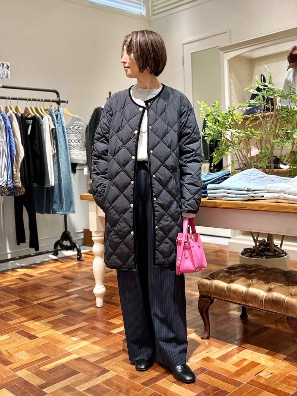 ブラック系のダウンジャケット/コート、グレー系のニット/セーター、ブルー系のその他パンツを着用したレディースの秋コーディネートの2枚目の写真