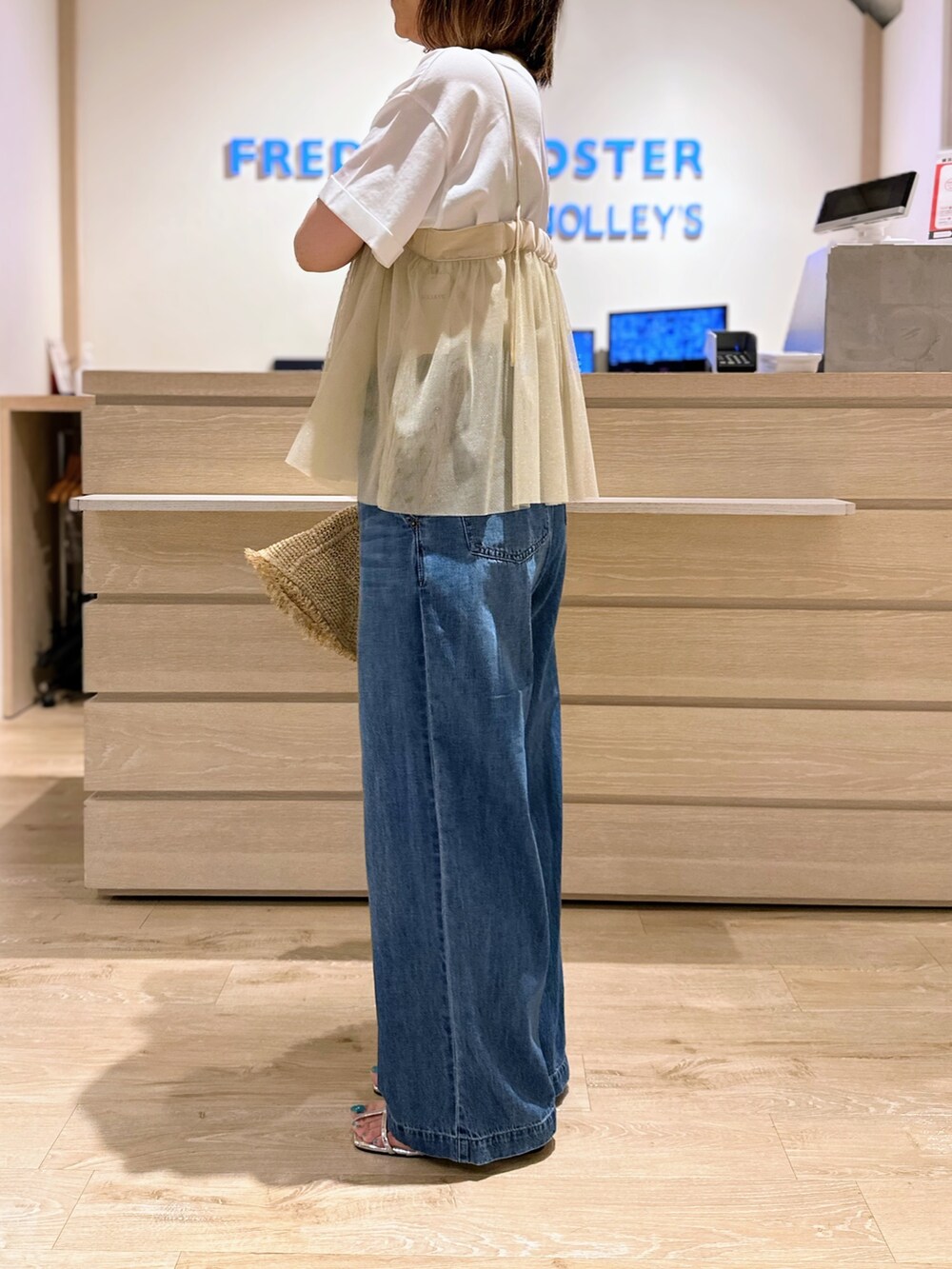 ブルー系のデニムパンツ、ホワイト系のTシャツ/カットソー、ベージュ系のシャツ/ブラウスを着用したレディースの夏コーディネートの2枚目の写真