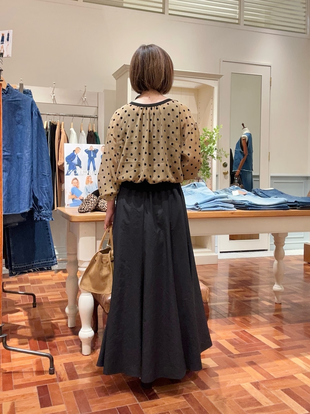 ブラック系のタンクトップ、イエロー系のカーディガン/ボレロ、ブラック系のスカートを着用したレディースの夏コーディネートの4枚目の写真