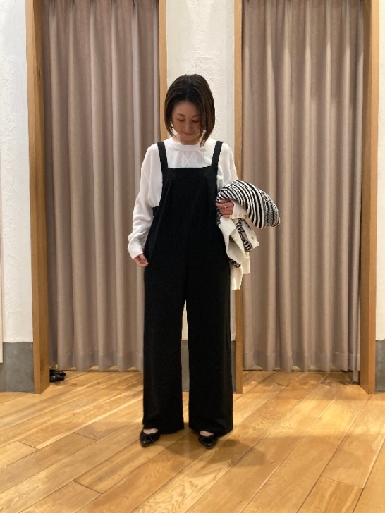 ホワイト系のカーディガン/ボレロ、ホワイト系のシャツ/ブラウス、ブラック系のサロペット/オーバーオールを着用したレディースの冬コーディネートの3枚目の写真