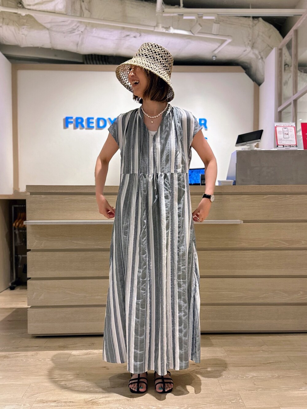 ブラック系のワンピース、ベージュ系のハットを着用したレディースの夏コーディネートの3枚目の写真