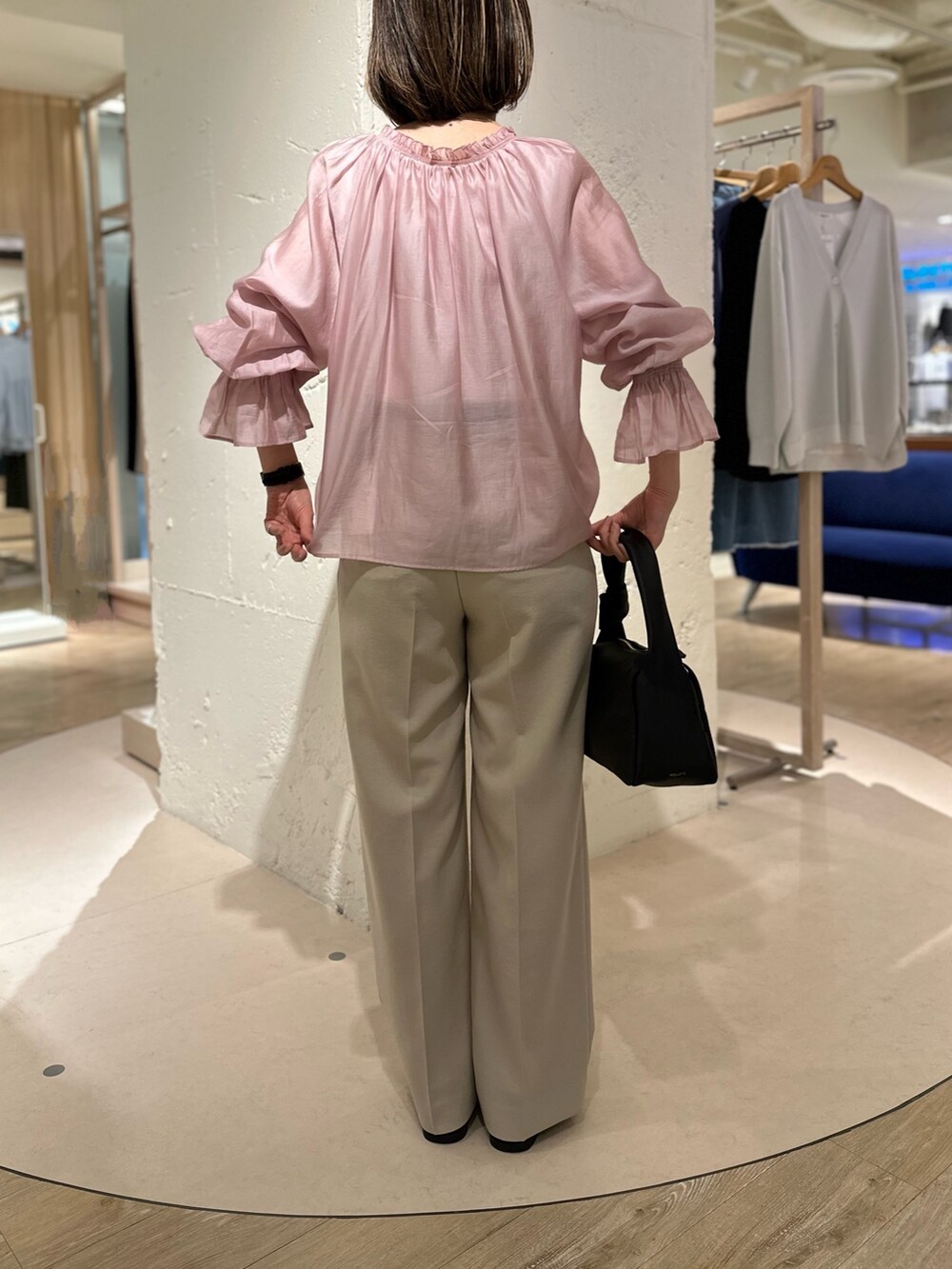 ピンク系のシャツ/ブラウス、ベージュ系のその他パンツ、ブラック系のショルダーバッグを着用したレディースの春コーディネートの3枚目の写真