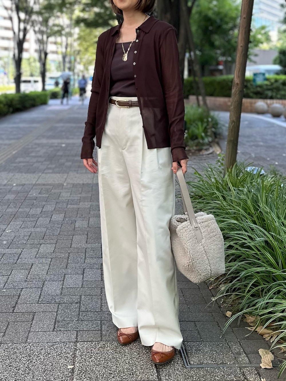 ブラウン系のカーディガン/ボレロ、ブラウン系のタンクトップ、ホワイト系のその他パンツを着用したレディースの秋コーディネートの10枚目の写真