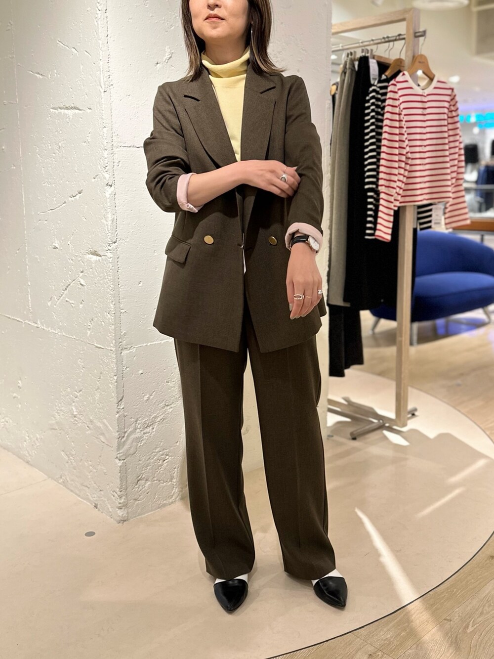 ブラウン系のテーラードジャケット、ブラウン系のその他パンツ、イエロー系のニット/セーターを着用したレディースの秋コーディネートの2枚目の写真